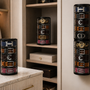 Two ELYPRO Rotating Belt Organizers in a walk-in closet, one on the dresser and one mounted on the wall, each holding rolled belts