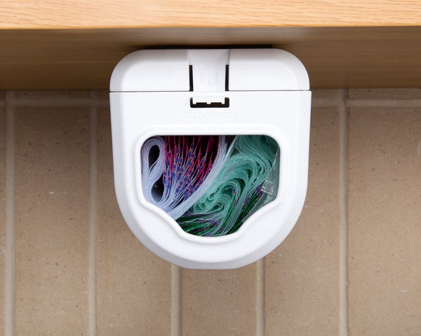 Front view of the dispenser under a cabinet, its window showing the co