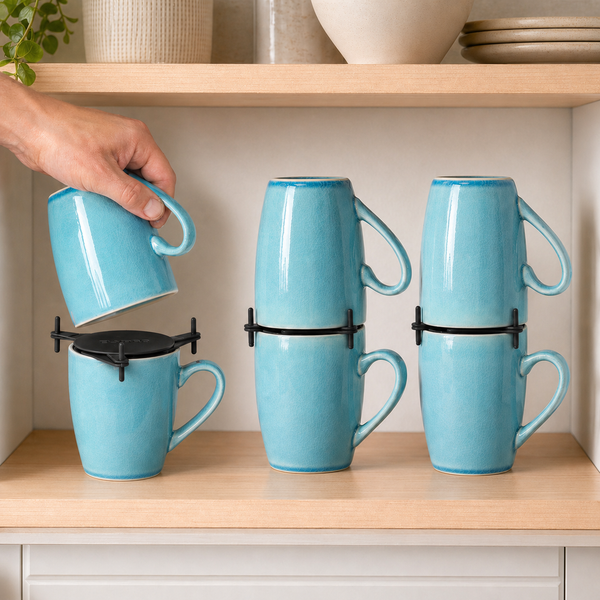 Black ELYPRO mug stackers holding three pairs of blue mugs on a kitchen cabinet shelf, with a hand lowering one mug into place