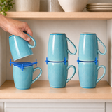 Blue ELYPRO mug stackers holding three pairs of blue mugs on a kitchen cabinet shelf, with a hand lowering one mug into place