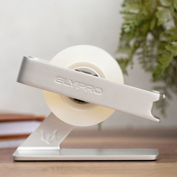 Silver ELYPRO tape dispenser holding a roll of clear tape on a wooden desk