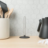 The empty organizer standing on a wooden counter between a utensil crock and a kettle