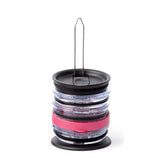 The organizer on a white background with black, clear and pink tumbler lids stacked on its post