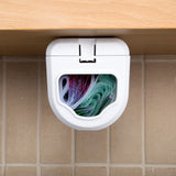 Front view of the dispenser under a cabinet, its window showing the coloured bags loaded inside